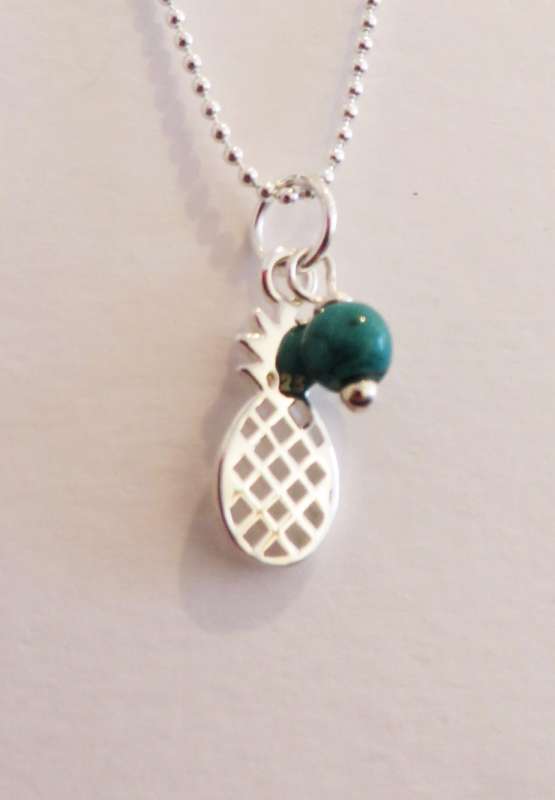 Silver pendant with pineapple charm and green stone